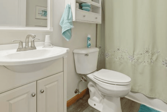 A bathroom with a white sink, toilet, and a shower curtain with a floral pattern.